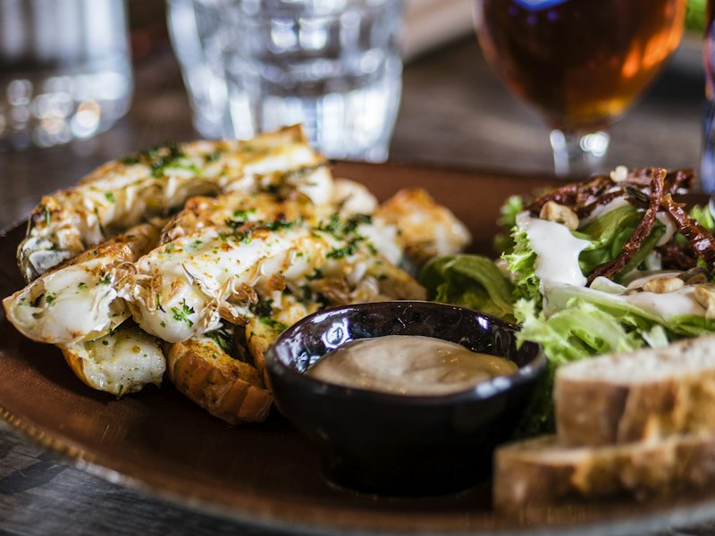 Plated restaurant meal with potatoes, salad and a bowl of dipping sauce