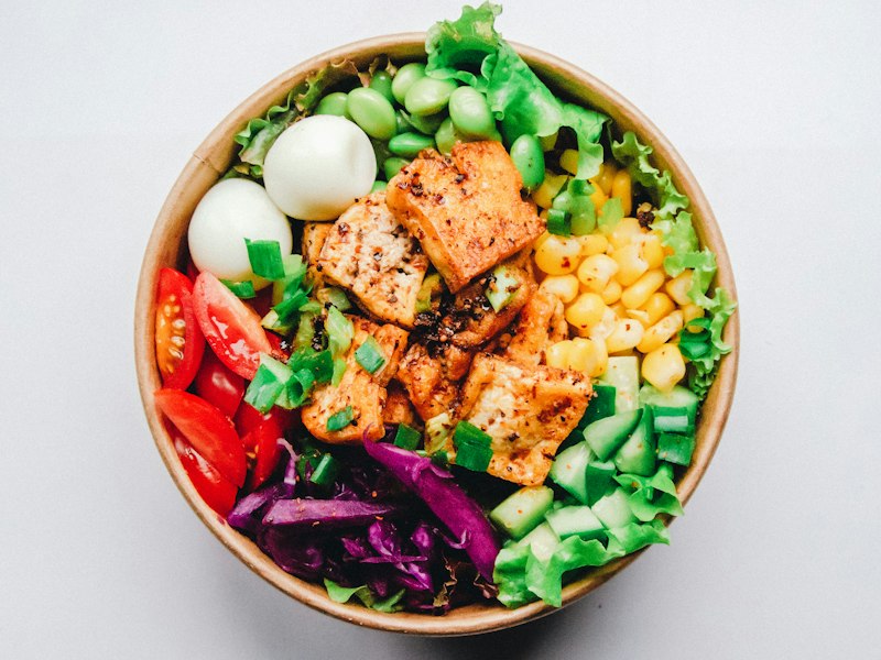 Colourful salad bowl with lettuce, corn, tomato and browned tofu