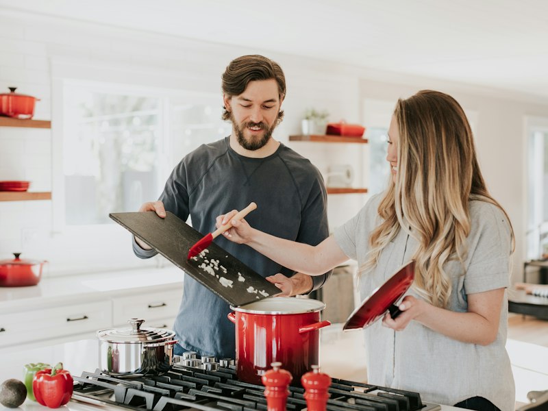 Two people preparing food together in a bright kitchen